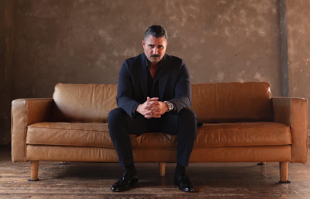 Bryan sitting on a sofa looking at the camera